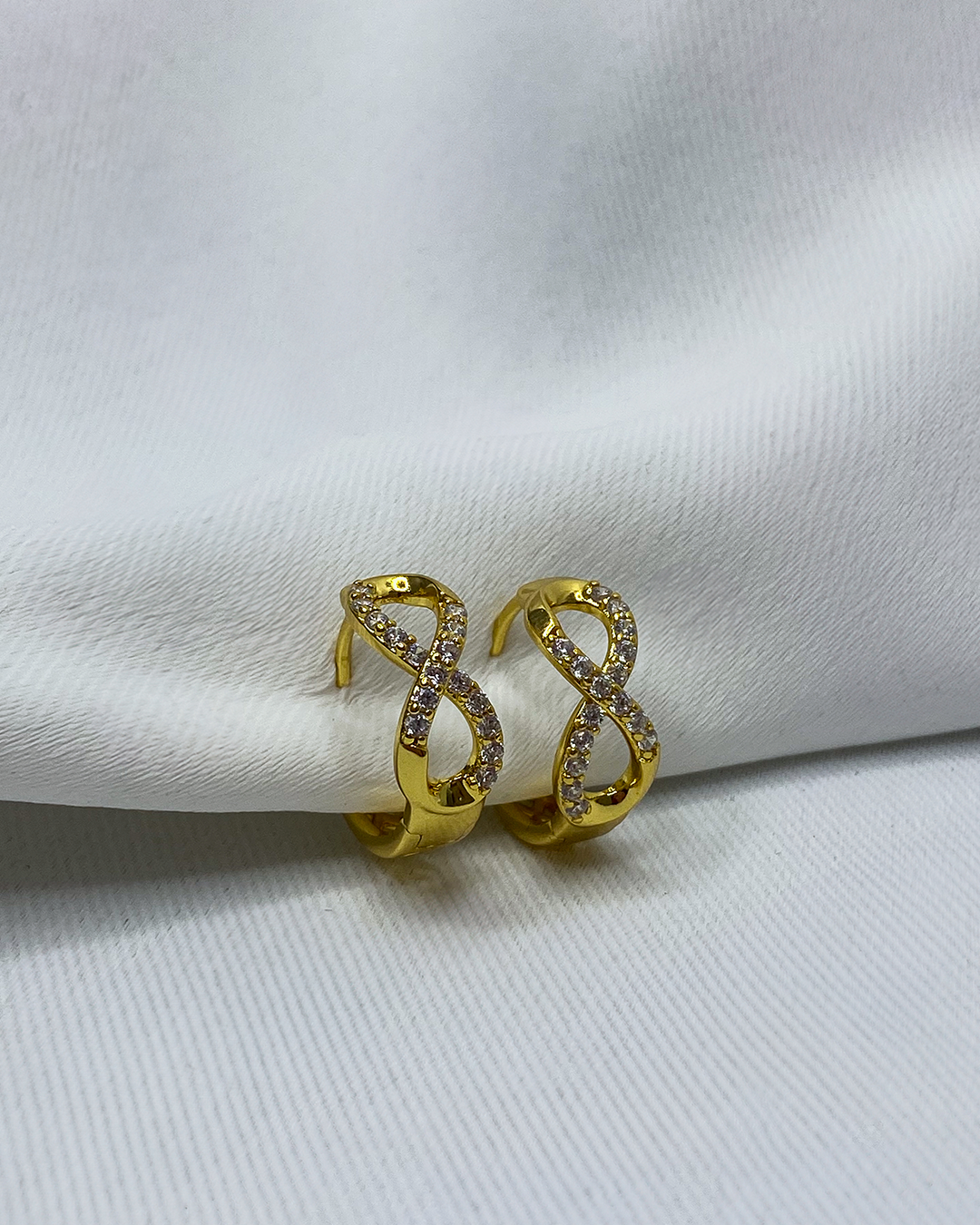Aretes con diseño de infinito con detalles brillantes enchapado en oro 18k acero inoxidable