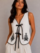 Blusa unicolor con bordados y lazos en frente