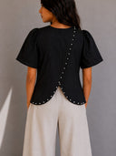 Blusa con flor y pedreria en la parte de atras